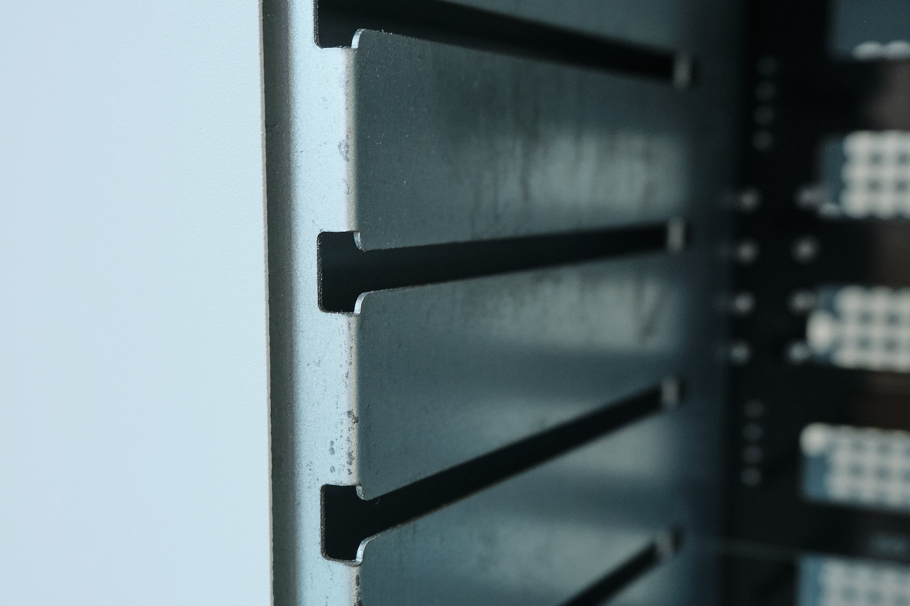 Close-up of the drive bay rails inside the Sagittarius NAS case, showing surface imperfections on the sheet metal